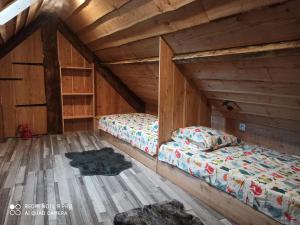 two beds in an attic room with wooden walls at Appart Chalet hyper centre in Cauterets