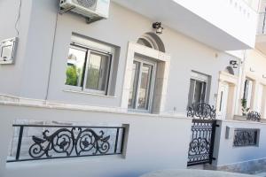 a white house with a black fence and windows at Estia in Kalymnos