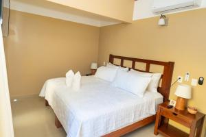 a bedroom with a white bed with two white pillows at The Garden Hotel in Palenque