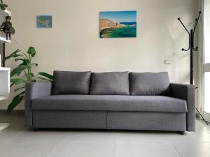 a couch in a living room with a picture on the wall at Villa Gelsomino in Avola