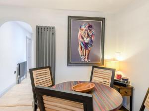 a dining room with a table and a painting on the wall at Orchard Retreat in Kirton