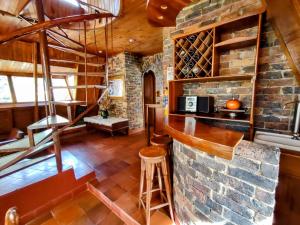 a tasting room with a stone wall and a bar at Refugio Génesis habitaciones Lago de Tota in Tota
