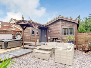 a backyard with a patio with a grill and a house at Orchard Retreat in Kirton