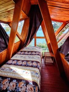 a bedroom with two beds in a wooden cabin at Refugio Génesis habitaciones Lago de Tota in Tota