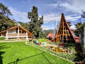une cour avec une maison et une aire de jeux dans l'établissement Refugio Génesis habitaciones Lago de Tota, à Tota
