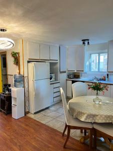uma cozinha com uma mesa e um frigorífico branco em apartment avec parking privé em Cidade de Quebec
