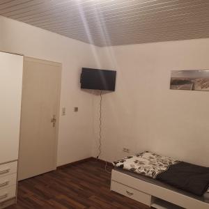 a bedroom with a bed and a flat screen tv on the wall at Ferienunterkunft Sson in Detmold