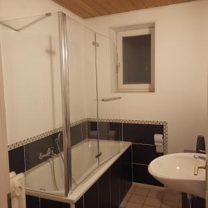 a bathroom with a shower and a tub and a sink at Ferienunterkunft Sson in Detmold