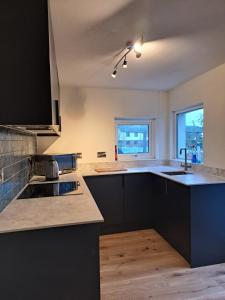 uma cozinha com armários pretos e um lavatório em Adail Cottage em Aberystwyth