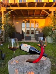 a bottle of wine and a glass of red wine at Langhe Wine & Relax in Novello