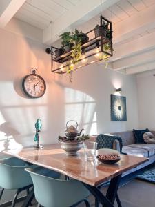 een eettafel met stoelen en een klok aan de muur bij Langhe Wine & Relax in Novello