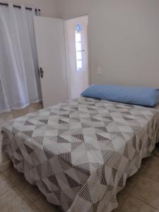 1 dormitorio con cama con edredón en Linda vista para o mar, en Cabo Frío