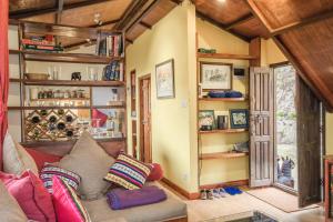 un soggiorno con divano e alcuni scaffali di Shivapuri Heights Cottage a Kathmandu