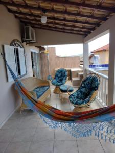 una hamaca en un porche con sillas y mesa en Linda vista para o mar, en Cabo Frío