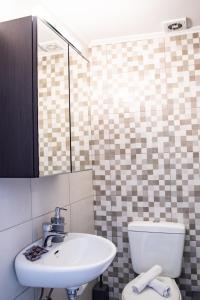 een badkamer met een witte wastafel en een toilet bij Beautiful, Brand New Apartment with Courtyard. in Heraklion