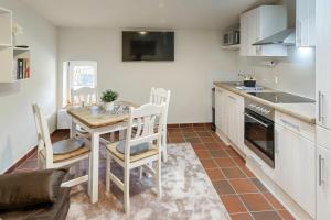 a kitchen with a table and chairs in a room at Natur pur! Exklusive Ferienwohnungen in historischer Poststation Bornkrug in Linstow
