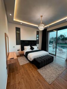 a bedroom with a large bed and a chandelier at Villa 7palms in Marrakech +10 photos