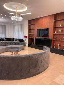 a large living room with a couch and a tv at Villa 7palms in Marrakech