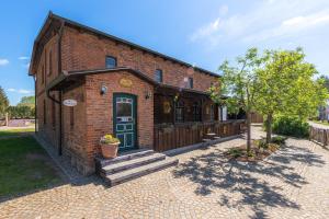 a brick building with a green door and a porch at Natur pur! Exklusive Ferienwohnungen in historischer Poststation Bornkrug in Linstow