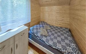 una piccola camera con un letto in una cabina di legno di Cozy Home In Postomino With Outdoor Swimming Pool a Postomino