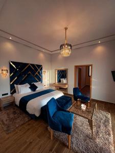 1 dormitorio con 1 cama, sillas azules y mesa en Villa 7palms, en Marrakech