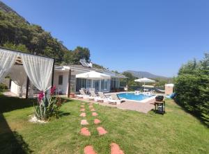 a backyard with a swimming pool and a house at BegonVilla Fethiye-Göcek in Muğla
