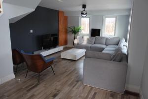 un soggiorno con divano e TV di Entire Luxurious Waterfront Peninsula Cottage - 7 Bedroom with Hottub a Marmora