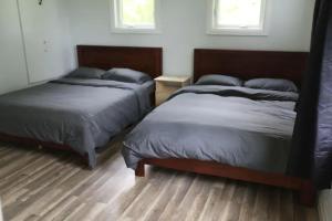 2 letti in una camera con pavimenti e finestre in legno di Entire Luxurious Waterfront Peninsula Cottage - 7 Bedroom with Hottub a Marmora