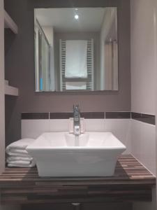 W łazience znajduje się biała umywalka i lustro. w obiekcie The Lodge w mieście King's Lynn