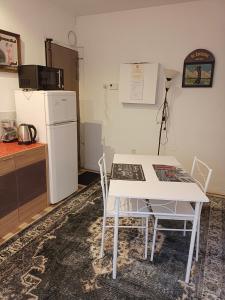 uma cozinha com uma mesa e cadeiras brancas e um frigorífico em Ivone guest em Maisons-Alfort