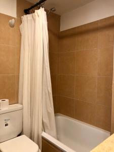 a bathroom with a toilet and a shower curtain at Güemes Premium, 2 dorm con Vista a las Sierras ALOHA #2 in Córdoba