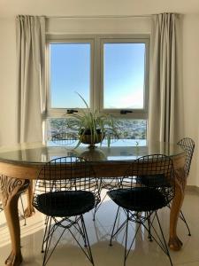 mesa de comedor con sillas y ventana en Güemes Premium, 2 dorm con Vista a las Sierras ALOHA #2 en Córdoba