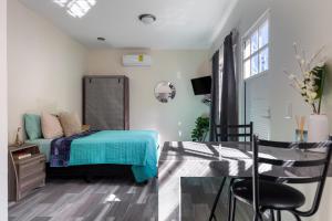 a bedroom with a bed and a table and a chair at El depa de Acuario in Cancún