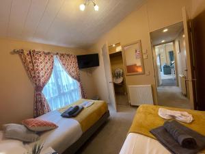 a hotel room with two beds and a window at Luxury Lakeside Lodge L2 with Hot tub situated at Tattershall Lakes Country Park in Tattershall