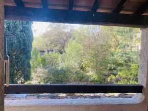 an open window with a view of a forest at Le Patio Bleu in La Crau