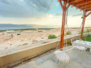 a porch with two chairs and a view of the desert at Charming unit in Dead Sea in Ovnat