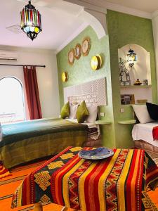 una camera con 2 letti, uno specchio e un letto sidx sidx. di Auberge Tissadrine ad Akhendachou nʼAït Ouffi