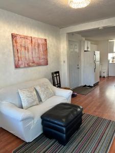 a white couch with a stool in a living room at appartement avec 2 chambres in Quebec City