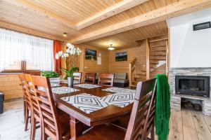 a dining room with a table and a fireplace at Widokowe Domki Gawlaki in Zakopane