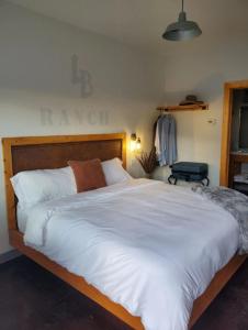 um quarto com uma cama grande e lençóis brancos em Lazy Bear Ranch em Weiser