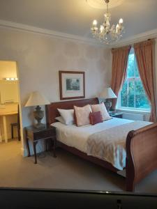 a bedroom with a bed and a chandelier at The Lodge in King's Lynn
