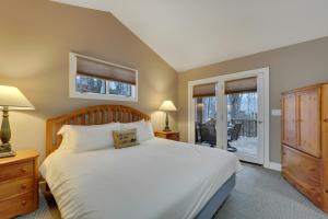 a bedroom with a large bed and a balcony at 728 Disciples Village Condo in Boyne Falls