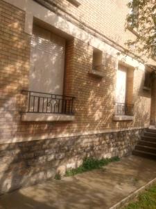 a brick building with two windows and a balcony at Ivone guest in Maisons-Alfort