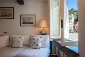 un soggiorno con divano e finestra di Casa Smeraldo by PortofinoVip a Portofino