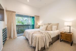 a bedroom with a bed and a large window at Swell Byron Bay - Opposite the Belongil Beach in Byron Bay