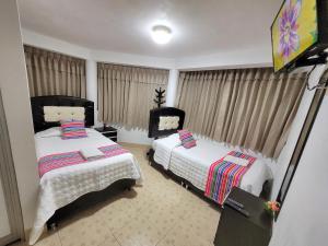 1 dormitorio con 2 camas y cortinas en Hostal EL VIAJERO en Ollantaytambo en Ollantaytambo