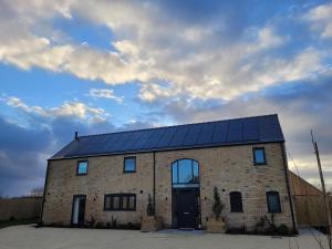 林肯的住宿－Lindum Barn, Ashlin Farm Barns，屋顶上设有太阳能电池板的砖屋