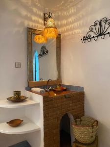 a bathroom with a mirror and a brick fireplace at Auberge Tissadrine in Akhendachou nʼAït Ouffi