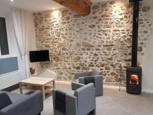a living room with a stone wall with a fireplace at Gîte La Terrasse in Couffoulens