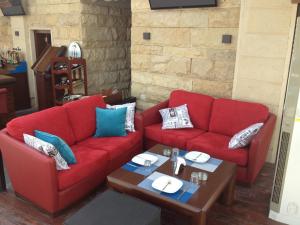 a living room with two red couches and a table at Fiori Hotel in Erbil